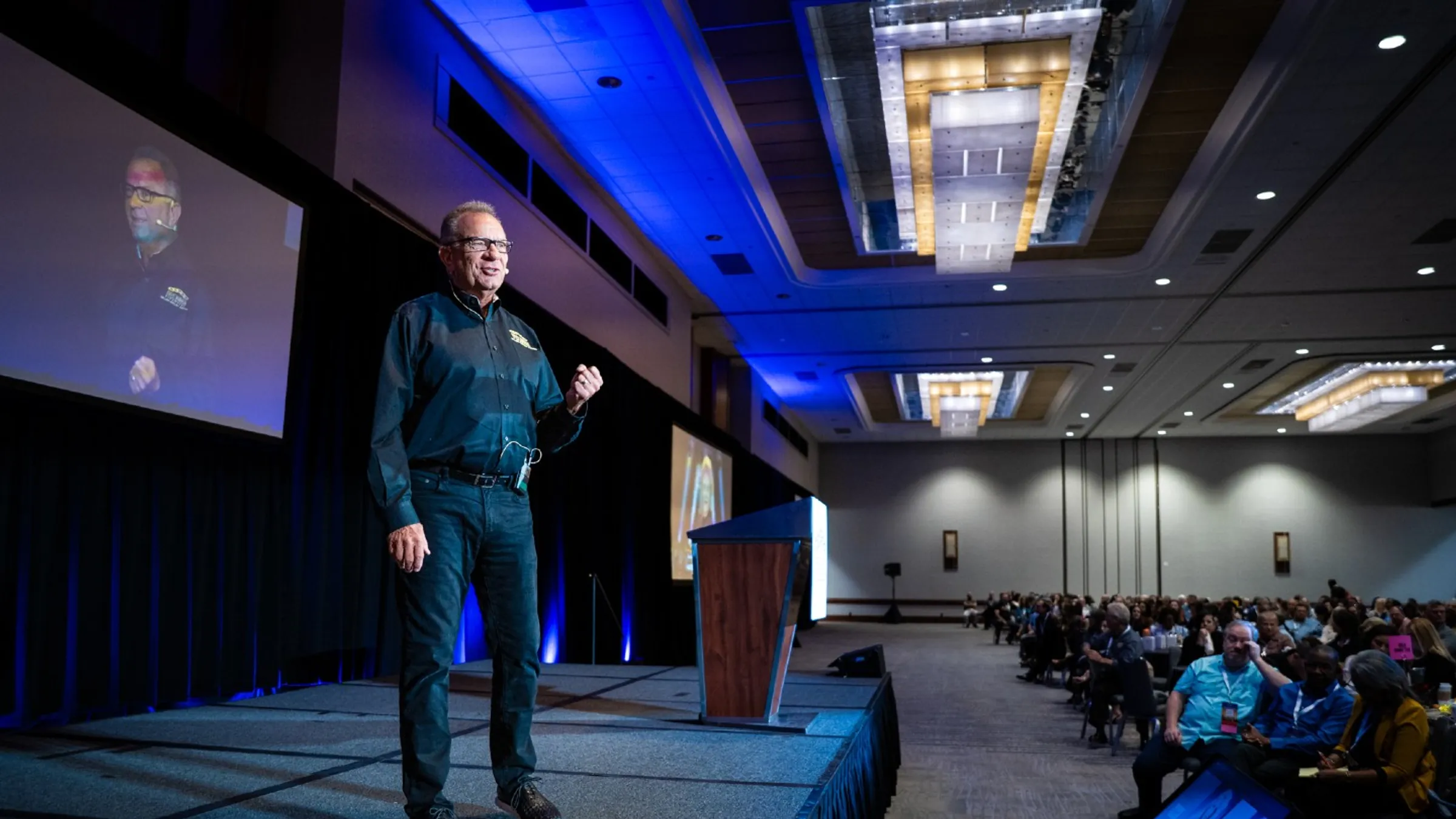 Mike Wilk speaking on stage at a past Five Rings Financial event.